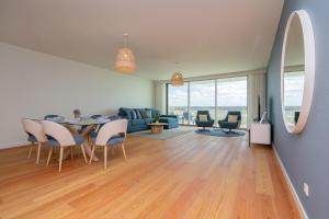 a dining room and living room with a table and chairs at Bayline X in Armação de Pêra