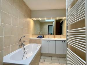 een badkamer met een bad, 2 wastafels en een spiegel bij OPt7 in Arnemuiden +49 foto's