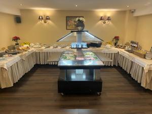 een eetkamer met tafels met witte tafelkleden bij Classic Inn Hotel by Radacini in Braşov