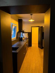 een keuken met zwarte kasten en een gele muur bij Sān home’s in Antwerpen +65 foto's