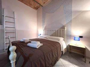 ein Schlafzimmer mit einem großen Bett, auf dem Handtücher liegen in der Unterkunft Il Nido delle Logge in Siena