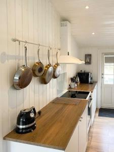 a kitchen with pots and pans hanging from the wall at Beach House Near Sejerø Bay in Hønsinge