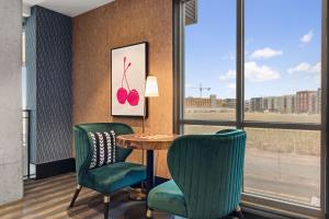 a room with a table and two green chairs at Kasa Rino Denver in Denver