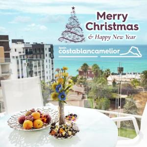 Un árbol de Navidad y un plato de fruta sobre una mesa. en Calpe Beach, en Calpe