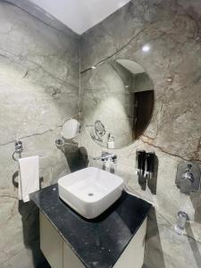 a bathroom with a sink and a mirror at Hotel Supreme Inn in Varanasi +6 photos