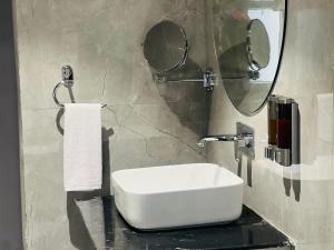 a bathroom with a white sink and a mirror at Hotel Supreme Inn in Varanasi