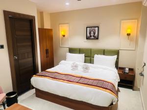 a bedroom with a large bed with white sheets at Hotel Supreme Inn in Varanasi