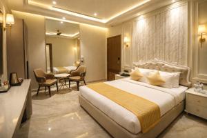 卢迪亚纳Crown Palazzo的一间带床、桌椅的酒店房间