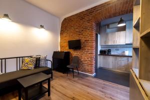 a living room with a couch and a brick wall at Apartamente Lux Unirii in Timişoara