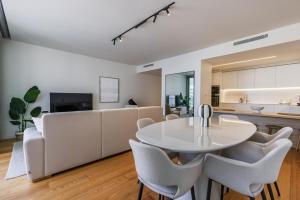 a dining room and kitchen with a white table and chairs at Bayline Solaris 4 in Armação de Pêra
