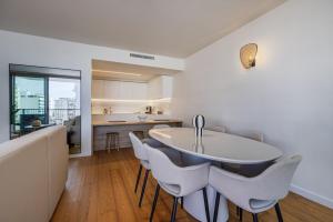 a kitchen and dining room with a white table and chairs at Bayline Solaris 4 in Armação de Pêra +62 photos
