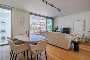 a living room with a table and chairs and a couch at Bayline Solaris 4 in Armação de Pêra