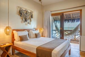 a bedroom with a bed and a large window at Pousada Preamar in Prea