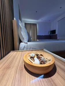 Un cuenco de madera con comida sobre una mesa en una habitación. en Hotel Movida, en Casoria