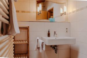 een badkamer met een wastafel en een spiegel bij Gästehaus Wechs in Bad Hindelang +42 foto's