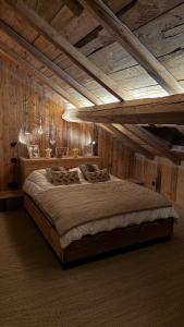 ein großes Bett in einem Zimmer mit Holzwänden in der Unterkunft Stone Lake Luxury Lodge in Gérardmer