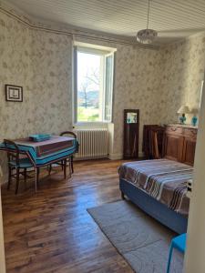 a bedroom with a bed and a table and a window at Au Moulin de Gary in Saint-Laurent-les-Tours