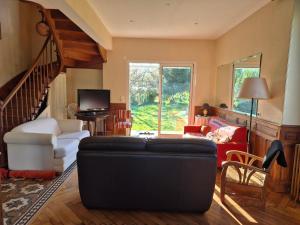 a living room with a couch and a staircase at Au Moulin de Gary in Saint-Laurent-les-Tours