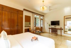 een slaapkamer met een wit bed en een bureau bij Jobner Haus Jaipur in Jaipur