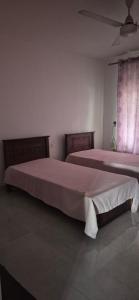 2 letti in una camera bianca con 2 letti sidx sidx sidx di Gardenia a Kandy