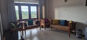 una sala d'attesa con sedie e una grande finestra di Gardenia a Kandy