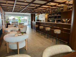 un restaurante con barra con taburetes y mesas en Hôtel Le Yachtman, The Originals Collection, en La Rochelle