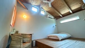 una camera da letto con un letto e una sedia in una stanza di 月みるいえ ad Akaogi