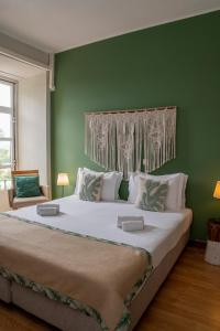 Cama grande en habitación con pared verde en WOT Sarrazola Soul, en Sintra