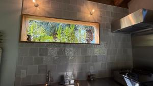 una cucina con finestra sopra un lavello; di 月みるいえ ad Akaogi