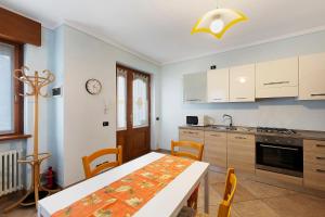 eine Küche mit einem Tisch und einem Tisch und Stühlen in der Unterkunft Residence Le Ante - Cadore in Santo Stefano di Cadore