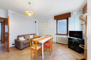 ein Wohnzimmer mit einem Tisch und einem Sofa in der Unterkunft Residence Le Ante - Cadore in Santo Stefano di Cadore