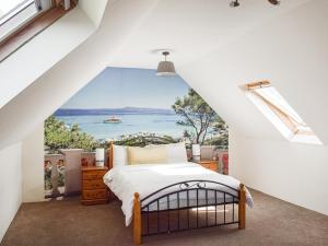 een slaapkamer met een bed met uitzicht op de oceaan bij Old Barn Cottage - Uk47144 in Glasgow +4 foto's