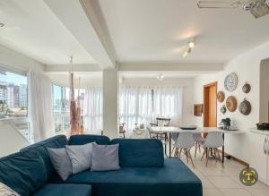 a living room with a blue couch and a table at Aproveitando o Sol e o Mar de Torres in Torres