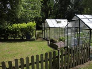 カンにあるCharming Chalet with Swimming Pool in Quendの柵の裏庭にある温室2棟