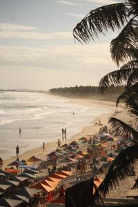 una playa con muchas sombrillas y gente en ella en Pousada Vilas do Frances, en Marechal Deodoro