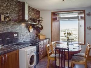 een keuken met een tafel en een eetkamer bij Old Barn Cottage - Uk47144 in Glasgow
