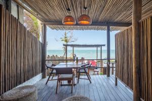 a wooden deck with a table and chairs and the ocean at Pousada Preamar in Prea