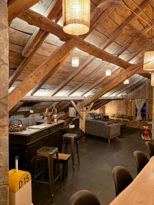 ein großes Wohnzimmer mit Holzdecken und einer Couch in der Unterkunft Stone Lake Luxury Lodge in Gérardmer