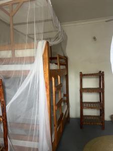 a bedroom with two bunk beds and a ladder at Mambo Leo Hostel in Paje