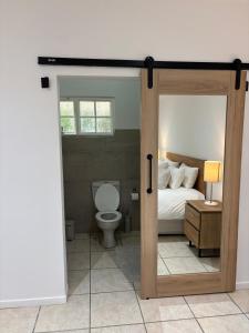 a bedroom with a door open to a bed and a toilet at Addo Good Hope Guest House in Sunland