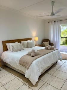 a bedroom with a large white bed with towels on it at Addo Good Hope Guest House in Sunland