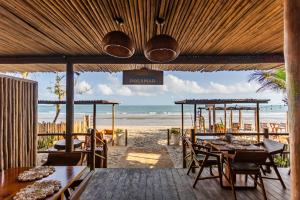 a restaurant on the beach with tables and chairs at Pousada Preamar in Prea