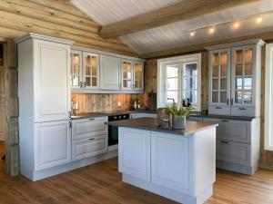 eine große weiße Küche mit weißen Schränken und einer Holzdecke in der Unterkunft Cabin With Panoramic View In Synnfjell in Nord Torpa