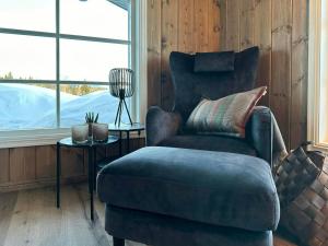 ein Wohnzimmer mit einem Stuhl und einem Tisch in der Unterkunft Cabin With Panoramic View In Synnfjell in Nord Torpa