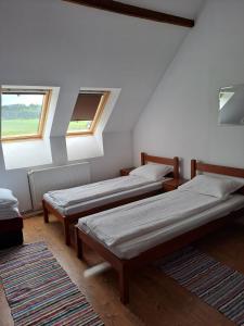 due letti in una stanza con due finestre di Pensiunea Rose a Păuleni-Ciuc
