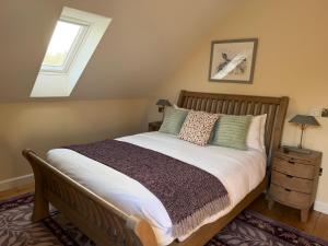een slaapkamer met een bed met een houten hoofdeinde bij Meadow View House at Pudleston Court in Docklow