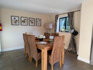 een eetkamer met een houten tafel en stoelen bij Meadow View House at Pudleston Court in Docklow