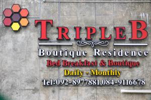 a sign for a restaurant on the side of a building at Triple B Boutique Residence in Si Racha