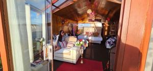 una mujer sentada en un sofá en una habitación en Titikaka Encantos Lodge, en Puno