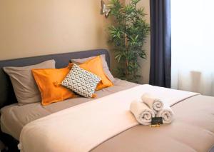 een bed met handdoeken en kussens erop bij Appartement Centre Saint-Omer, Parking privé gratuit in Saint-Omer